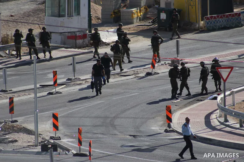Israeli security forces gather at the scene where troops reportedly ahot and killed a Palestinain woman who they say approached the entrance of the Jewish settlement of Kiryat Arba'a with a gun and fired shots, in the We...