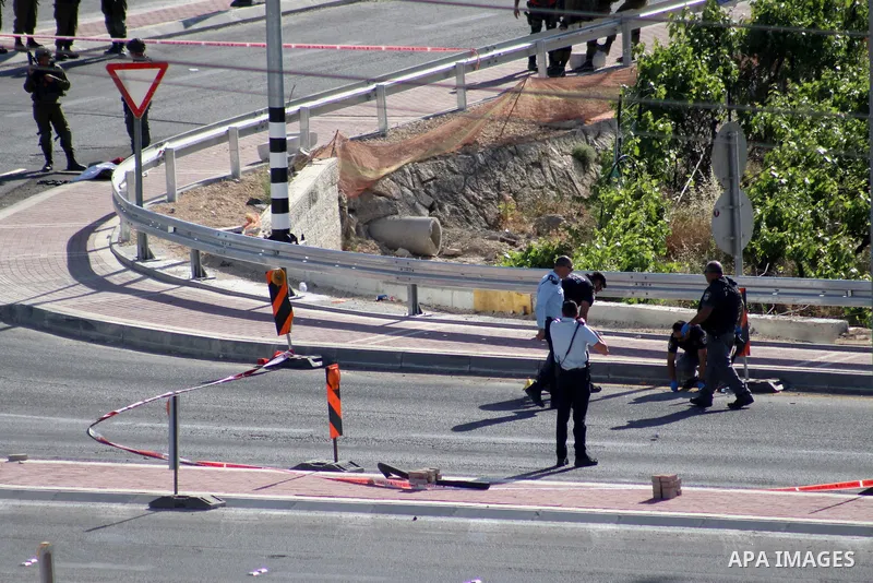 Israeli security forces gather at the scene where troops reportedly ahot and killed a Palestinain woman who they say approached the entrance of the Jewish settlement of Kiryat Arba'a with a gun and fired shots, in the We...