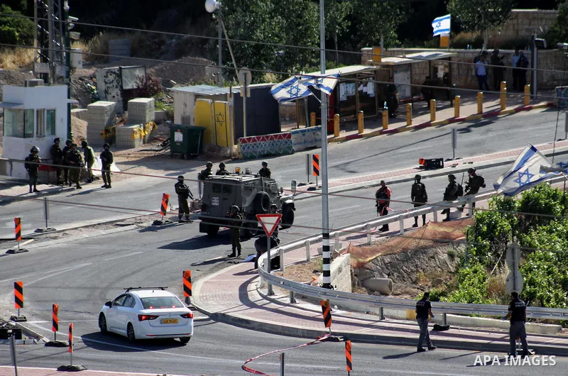 Israeli security forces gather at the scene where troops reportedly ahot and killed a Palestinain woman who they say approached the entrance of the Jewish settlement of Kiryat Arba'a with a gun and fired shots, in the We...