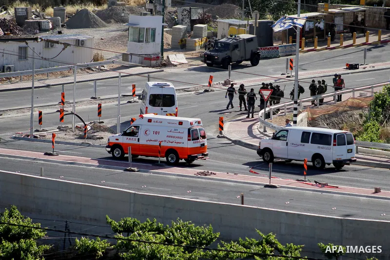 Israeli security forces gather at the scene where troops reportedly ahot and killed a Palestinain woman who they say approached the entrance of the Jewish settlement of Kiryat Arba'a with a gun and fired shots, in the We...