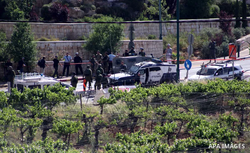 Israeli security forces gather at the scene where troops reportedly ahot and killed a Palestinain woman who they say approached the entrance of the Jewish settlement of Kiryat Arba'a with a gun and fired shots, in the We...