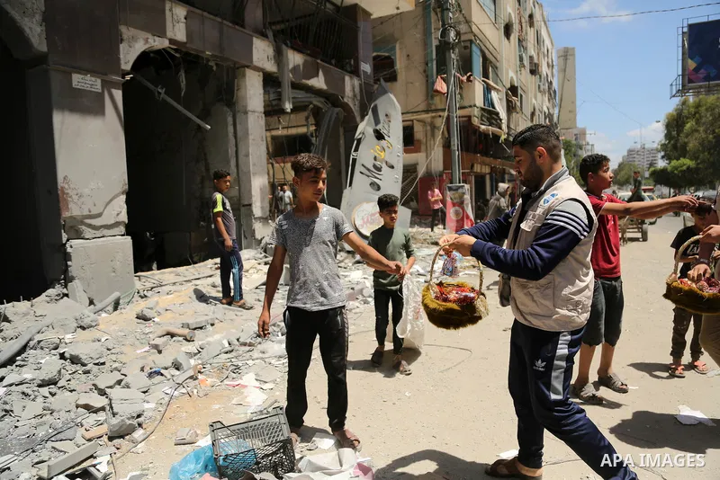 Palestinians walk past a building destroyed by Israeli missile strikes in Gaza City on May 22, 2021, following a ceasefire between Israel and Hamas movment. UNICEF delivered today lifesaving critical humanitarian supplie...