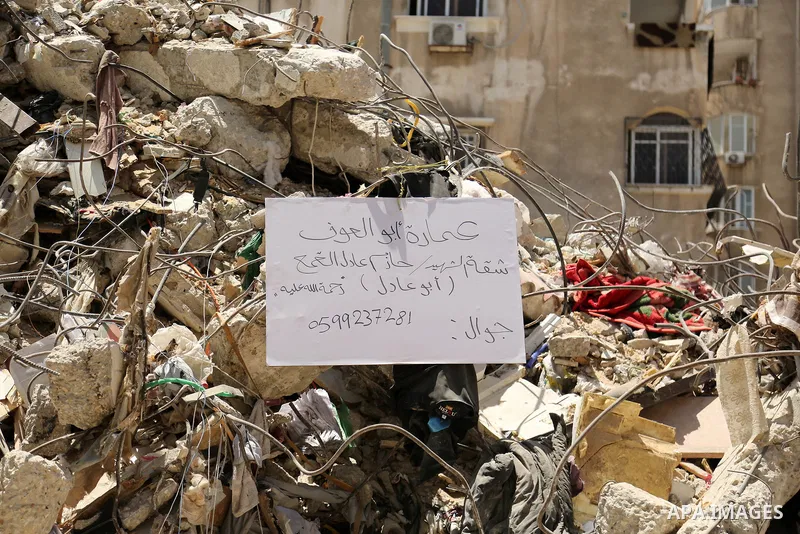 Palestinians walk past a building destroyed by Israeli missile strikes in Gaza City on May 22, 2021, following a ceasefire between Israel and Hamas movment. UNICEF delivered today lifesaving critical humanitarian supplie...