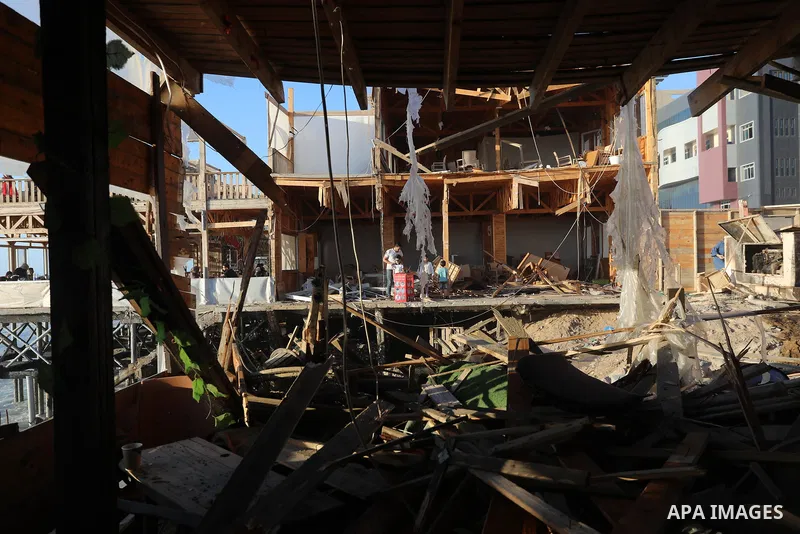 Palestinians enjoy their time in a cafe damaged by Israeli airstrike on the beach in Gaza city, on May 23, 2021. Gazans tried to piece back their lives after a devastating 11-day conflict with Israel that killed more tha...