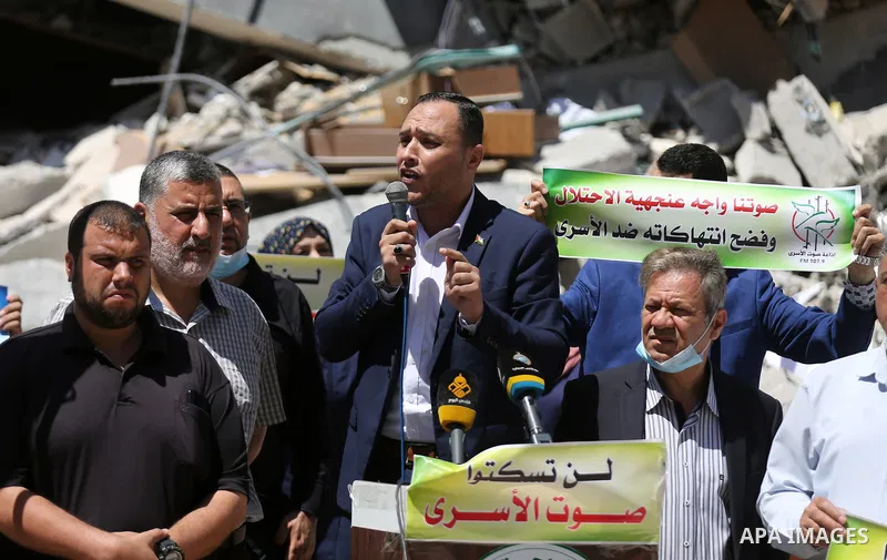 Palestinian Journalists from the Voice of the Prisoners Radio take part during anti-Israel rally, in front of Jala' Tower which destroyed on May 15 during Israeli air-strike in Gaza city on May 24, 2021. A ceasefire betw...