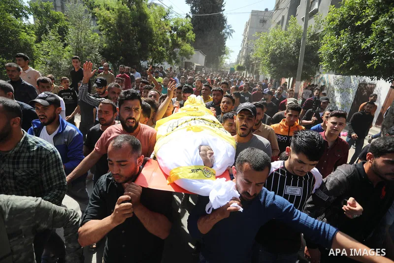 Relatives carry the body of Palestinian Mahmoud Abu Jarad during his funeral in Beit Hanun in the northern Gaza Strip on May 24, 2021, after he died from wounds sustained during the latest conflict with Israel. Photo by...
