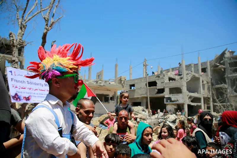 Palestinian clowns perform for children next to the rubble of houses which were destroyed by Israeli air strikes earlier this month in Beit Hanoun in the northern Gaza Strip on May 24, 2021. A ceasefire was reached late...