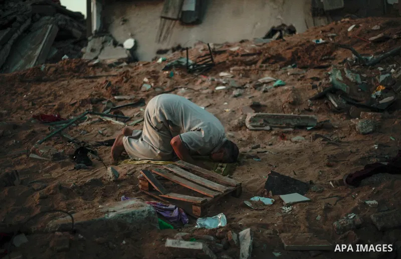 A Palestinian man prays on top of the ruins of a building destroyed in recent Israeli air strikes, in the northern of in Gaza strip, on May 24. 2021. Gazans tried to piece back their lives after a devastating 11-day conf...