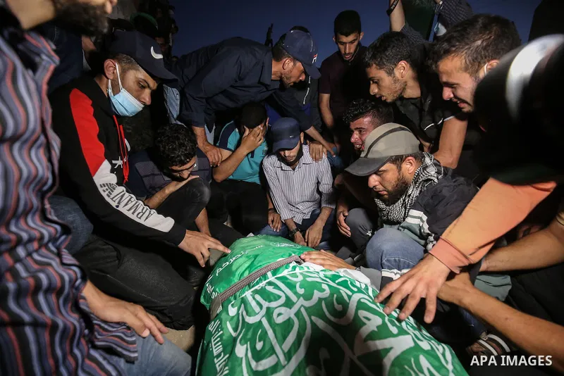 Palestinians mourn over the bodies of members of the Ezz-Al Din Al-Qassam Brigades, the armed wing of the Hamas movement, who reportedly died in Israeli bombardment of a tunnel, during a funeral, in Khan Yunis, in the so...