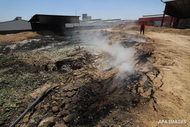 A Palestinian worker salvages items from the damaged Coca Cola factory in Gaza's industrial area, on May 25, 2021, which was hit by Israeli strikes prior to a cease-fire ending 11 days of deadly violence between Israel a...