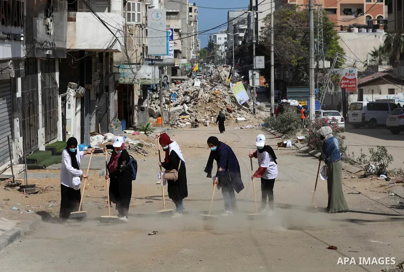 Palestinian volunteers and municipal workers clear the rubble of the buildings, recently destroyed by Israeli strikes, in Gaza City on May 25, 2021 after a cease-fire ending 11 days of deadly violence between Israel and...
