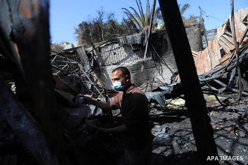 A Palestinian checks the destruction at an agricultural fertilisers factory targeted in recent Israeli air strikes, in Beit Lahia, in the northern of Gaza Strip on May 26, 2021. A ceasefire was reached late last week aft...