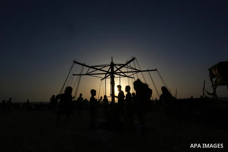 Palestinians spend time at the beach to escape the hot weather and the ongoing power cuts, in Deir al-Balah in the center of Gaza Strip on May 28, 2021. Photo by Ashraf Amra