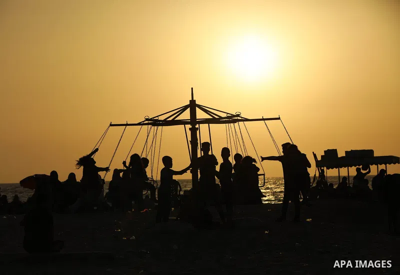 Palestinians spend time at the beach to escape the hot weather and the ongoing power cuts, in Deir al-Balah in the center of Gaza Strip on May 28, 2021. Photo by Ashraf Amra
