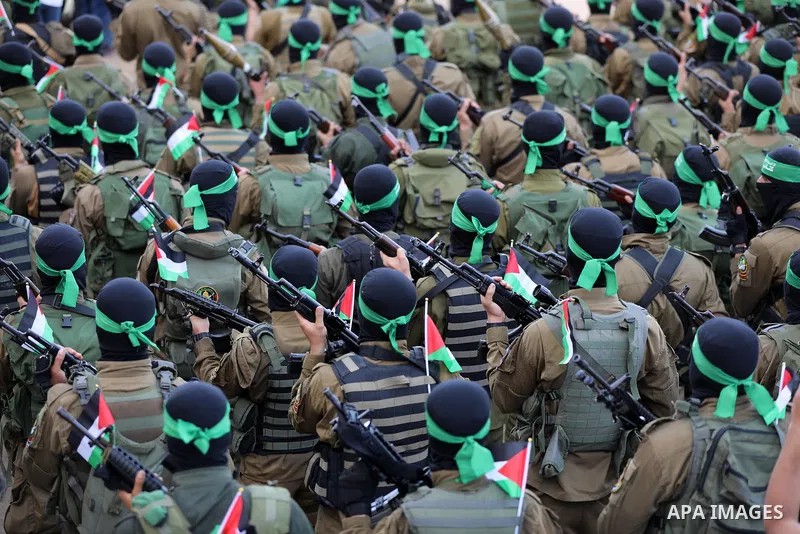 Members of Ezz-Al Din Al-Qassam Brigades, the armed wing of the Palestinian Hamas movement parade in an anti-Israel rally Al-Bureij refugee camp in the central Gaza Strip on May 28, 2021. - The Egyptian-brokered truce en...