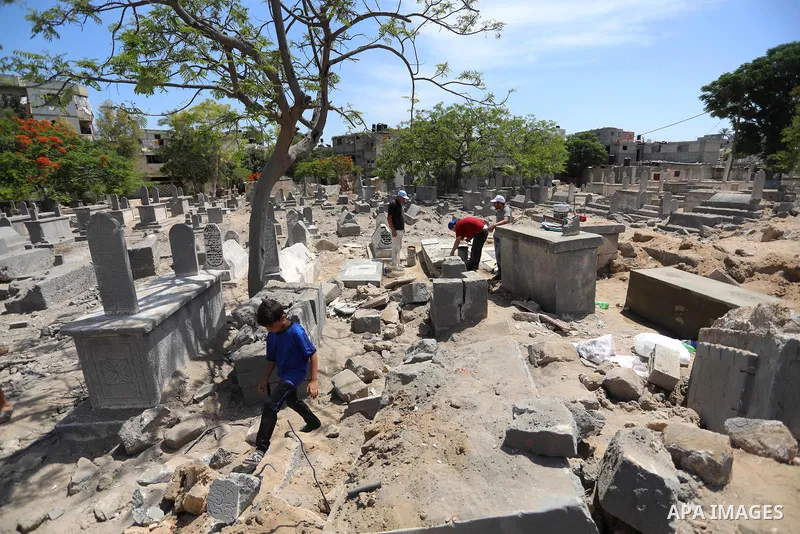 Palestinians inspect the damage around tombs in the old Shujaiya cemetery in Gaza City on May 30, 2021, after recent Israeli bombings. A ceasefire was reached late last week after 11 days of deadly violence between Israe...