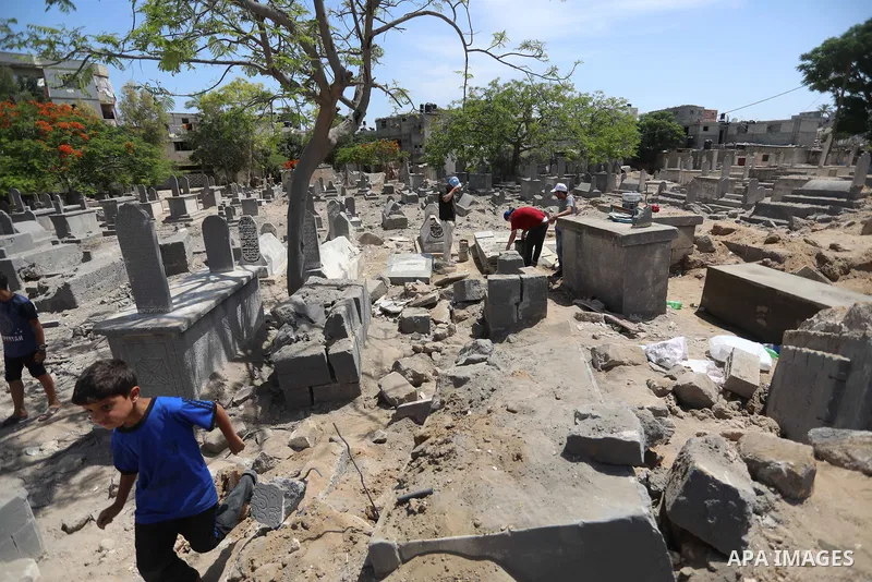 Palestinians inspect the damage around tombs in the old Shujaiya cemetery in Gaza City on May 30, 2021, after recent Israeli bombings. A ceasefire was reached late last week after 11 days of deadly violence between Israe...