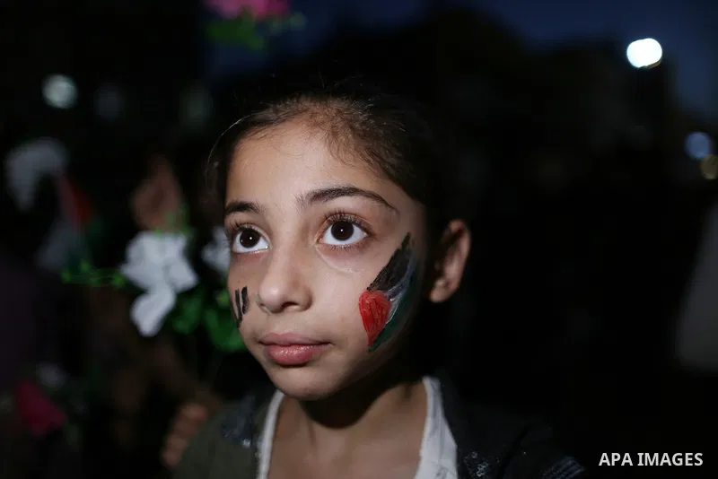 Palestinian children take part in a rally to light candles amid the ruins of houses destroyed by Israeli strikes, in Gaza City on May 30, 2021. The Egyptian-brokered truce ended 11 days of heavy Israeli bombing of Gaza a...