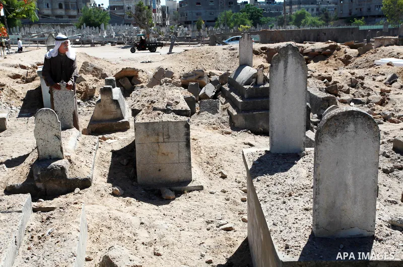 An elderly Palestinian man, 74, Mohammed Abu Al-Kas inspects graves of his relatives in a cemetery in the Shejaiya neighborhood, east of Gaza City, after dozens of graves were destroyed during the latest Israeli military...