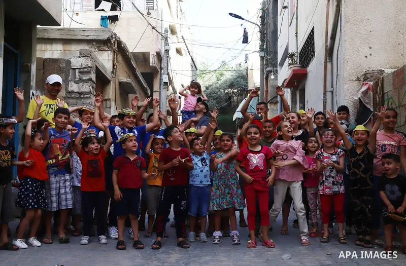 Palestinian children cheer during a mental health support session by Palestinian volunteers through acrobatic performances in Gaza city on June 9, 2021. As Gaza tries to recover from the deadly 11-day Israeli attack, mot...