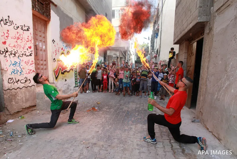 Palestinian volunteers perform acrobatic show in front of children during a mental health support session in Gaza city on June 9, 2021. As Gaza tries to recover from the deadly 11-day Israeli attack, mothers and mental h...