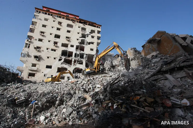 Palestinian workers and bulldozers remove the rubble of Hanadi Tower destroyed by Israeli air strikes last month, in Gaza city on June 9, 2021. Gaza’s housing ministry said on Thursday that 16,800 housing units had been...