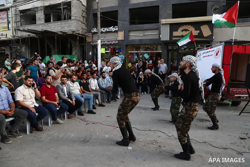 Palestinian Dabka band perform during an event "With blood, we write for Palestine" near the rubble of Shorouq tower destroyed by Israeli air strikes last month, in Gaza city on June 9, 2021. The Egyptian-brokered truce...