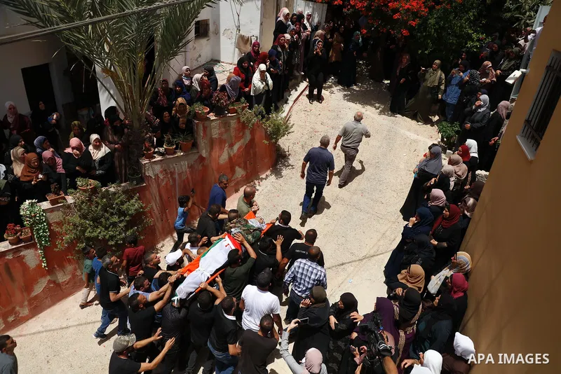 Mourners carry the body of Palestinian security man Tayseer Issa, who was killed by Israeli forces according to health ministry, during his funeral in the Werst bank city of Jenin, on June 10, 2021. Photo by Oday Daibes