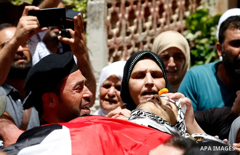 Members of Palestinian security forces carry the body of their comrade Adham Alioh, who was killed by Israeli forces according to health ministry, during his funeral in the West Bank city of Nablus on June 10, 2021. Phot...