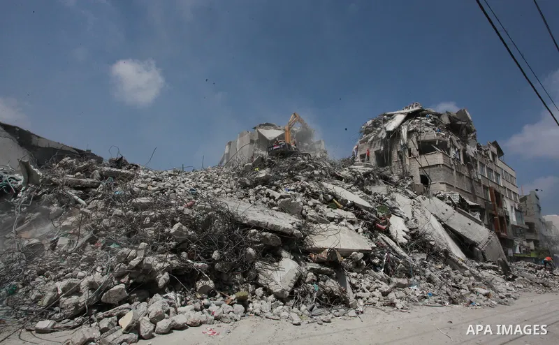 Egyptian workers and bulldozers sent from Egypt help to remove the rubble of Shorouq tower destroyed by Israeli air strikes last month in Gaza City on June 10, 2021. After brokering a ceasefire between the Israelis and H...