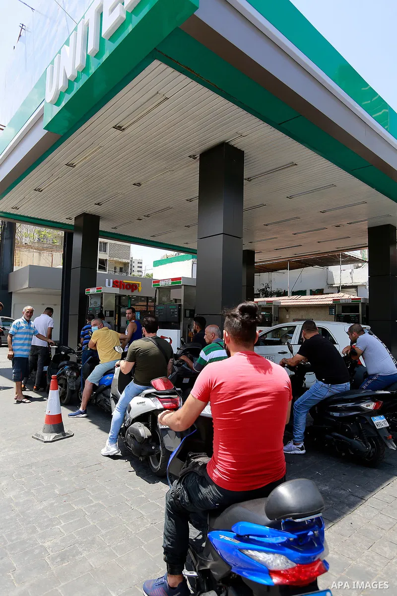 Lebanon employees fill cars with gasoline at a petrol station in Lebanon's capital Beirut on June 13, 2021, amidst severe fuel shortages. The fuel crisis, during the year 2021, has reached an acute level as the country's...