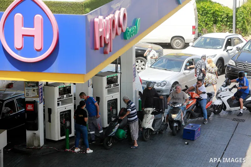 Lebanon employees fill cars with gasoline at a petrol station in Lebanon's capital Beirut on June 13, 2021, amidst severe fuel shortages. The fuel crisis, during the year 2021, has reached an acute level as the country's...