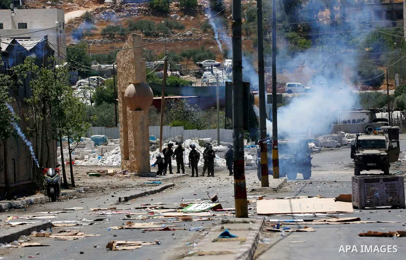 Israeli security forces take position during clashes with Palestinian demonstrators following a protest against Israeli settlements in the village of Beita near the West Bank city of Nablus, on June 18, 2021. Photo by Sh...