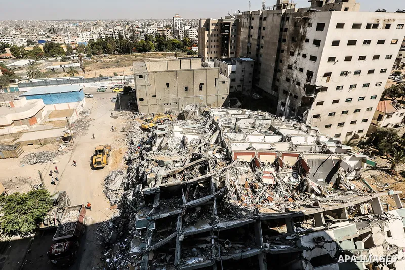 Egyptian workers and bulldozers sent from Egypt help to remove the rubble of Jala' Tower which destroyed on May 15 during Israeli air-strike, in Gaza city, on June 20, 2021. Photo by Bashar Taleb