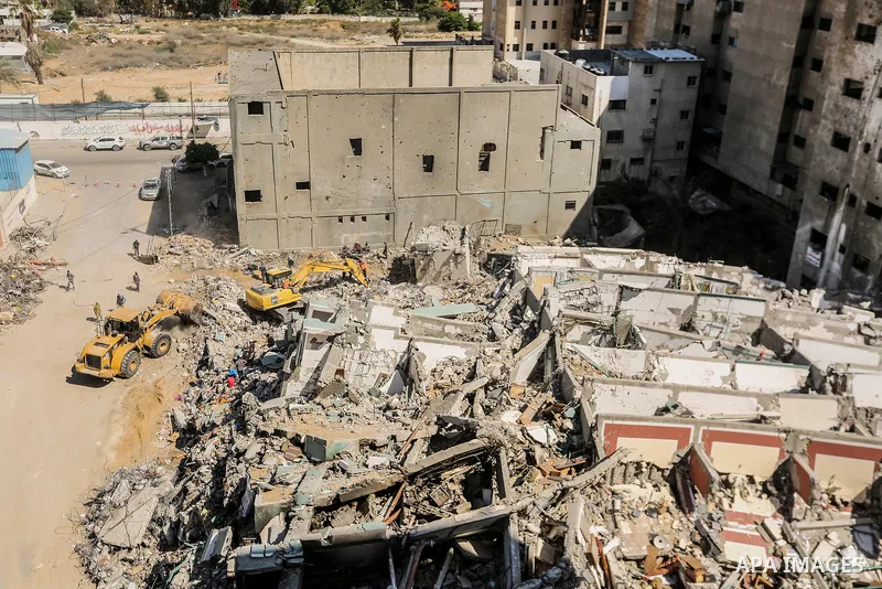 Egyptian workers and bulldozers sent from Egypt help to remove the rubble of Jala' Tower which destroyed on May 15 during Israeli air-strike, in Gaza city, on June 20, 2021. Photo by Bashar Taleb