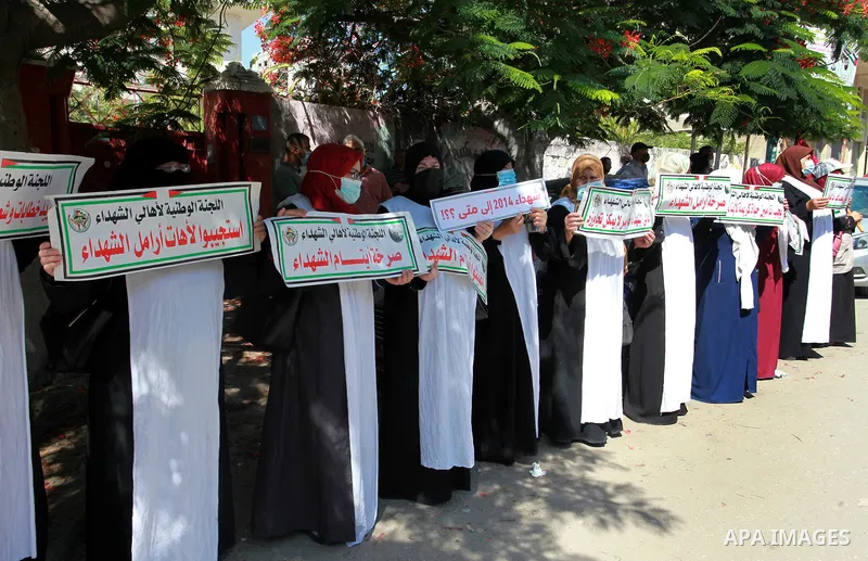 Families of Palestinian martyrs and wounded, take part in a protest against the Palestinian Authority's decision to cut their salaries for seven years, in front of the headquarters of Red cross in Gaza city, on June 21,...