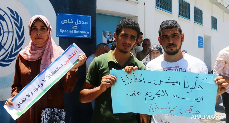 Palestinians of Union of Democratic Teachers committees, take part in a protest to demand job opportunities for the unemployed graduates, and reductions in programs and services provided to refugees, in front of the Unit...