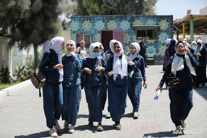 Palestinian students stand outside their school after completing the final high school exam, in Gaza City on June 24, 2021,amid concerns about the spread of the novel coronavirus pandemic. More than 84598 students in the...