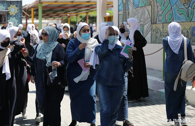 Palestinian students stand outside their school after completing the final high school exam, in Gaza City on June 24, 2021,amid concerns about the spread of the novel coronavirus pandemic. More than 84598 students in the...
