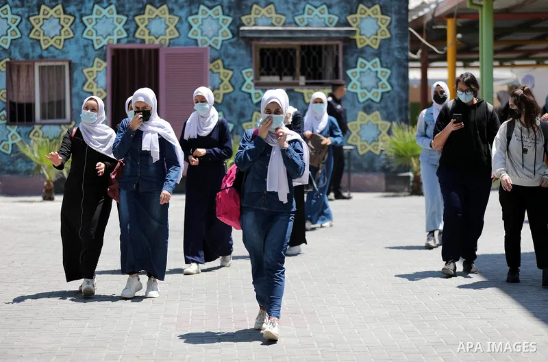 Palestinian students stand outside their school after completing the final high school exam, in Gaza City on June 24, 2021,amid concerns about the spread of the novel coronavirus pandemic. More than 84598 students in the...