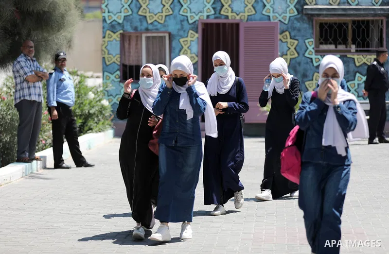 Palestinian students stand outside their school after completing the final high school exam, in Gaza City on June 24, 2021,amid concerns about the spread of the novel coronavirus pandemic. More than 84598 students in the...