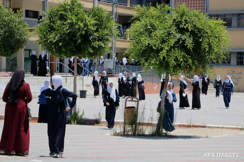 Palestinian female students stand outside their school after completing the final high school exam, in Rafah in the southern Gaza Strip on June 24, 2021, amid concerns about the spread of the novel coronavirus pandemic....