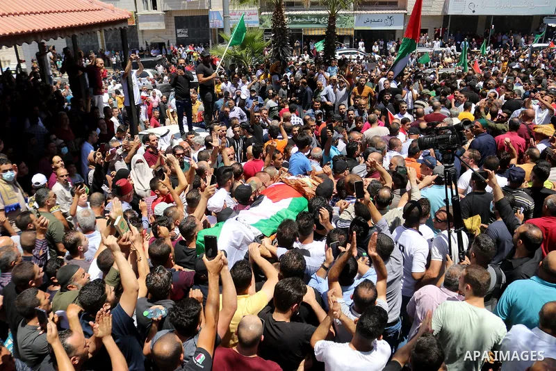 Mourners carry the body of human rights activist and Palestinian parliamentary candidate Nizar Banat, who died shortly after being arrested a day before during his funeral, in Hebron in the West Bank on June 25, 2021. Th...