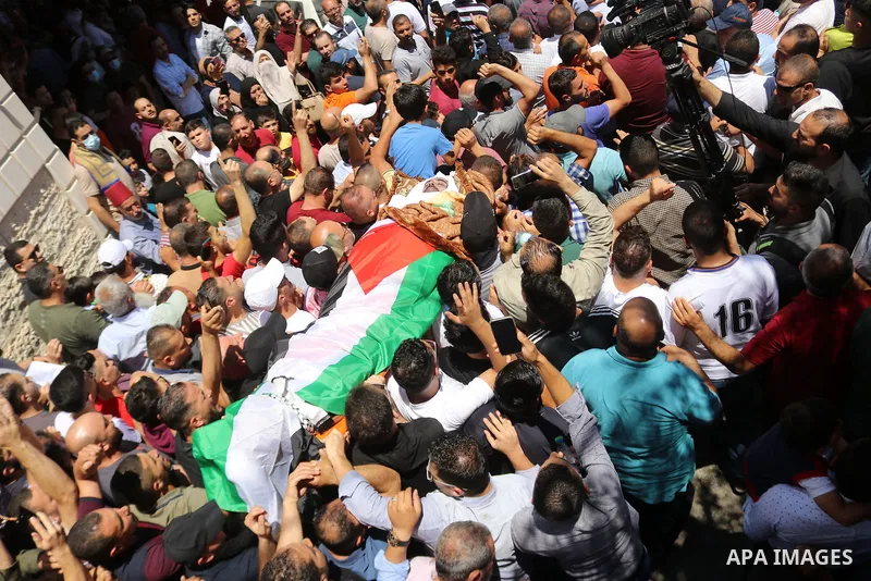 Mourners carry the body of human rights activist and Palestinian parliamentary candidate Nizar Banat, who died shortly after being arrested a day before during his funeral, in Hebron in the West Bank on June 25, 2021. Th...