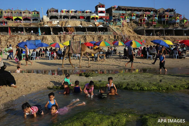 Palestinians enjoy their time on huts overlooking the beach of the Mediterranean sea in Deir al-Balah in the center of Gaza Strip, on June 25, 2021. The beach is one of the few open public spaces in this densely populate...
