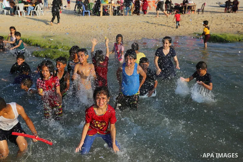 Palestinians enjoy the beach of the Mediterranean sea in Deir al-Balah in the center of Gaza Strip, on June 25, 2021. The beach is one of the few open public spaces in this densely populated city. Photo by Ashraf Amra