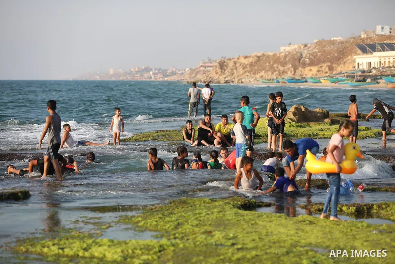 Palestinians enjoy the beach of the Mediterranean sea in Deir al-Balah in the center of Gaza Strip, on June 25, 2021. The beach is one of the few open public spaces in this densely populated city. Photo by Ashraf Amra