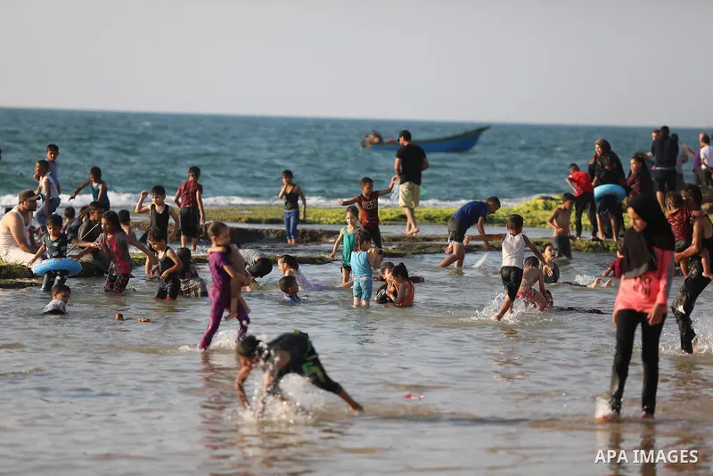 Palestinians enjoy the beach of the Mediterranean sea in Deir al-Balah in the center of Gaza Strip, on June 25, 2021. The beach is one of the few open public spaces in this densely populated city. Photo by Ashraf Amra