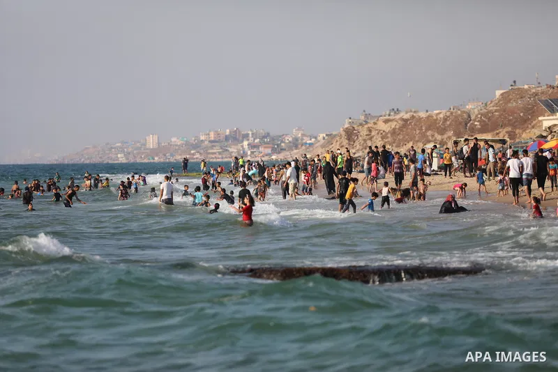 Palestinians enjoy the beach of the Mediterranean sea in Deir al-Balah in the center of Gaza Strip, on June 25, 2021. The beach is one of the few open public spaces in this densely populated city. Photo by Ashraf Amra