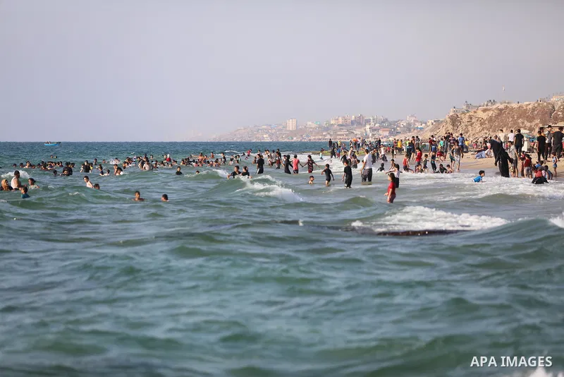 Palestinians enjoy the beach of the Mediterranean sea in Deir al-Balah in the center of Gaza Strip, on June 25, 2021. The beach is one of the few open public spaces in this densely populated city. Photo by Ashraf Amra